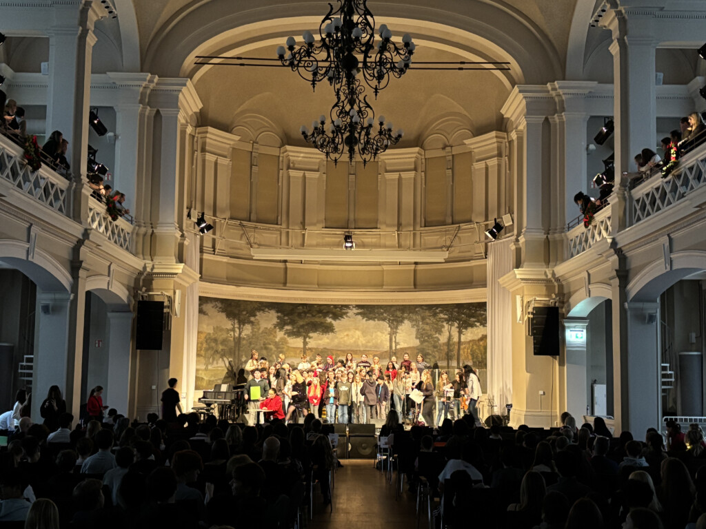 The Aula at Norra Latin with students performing on stage